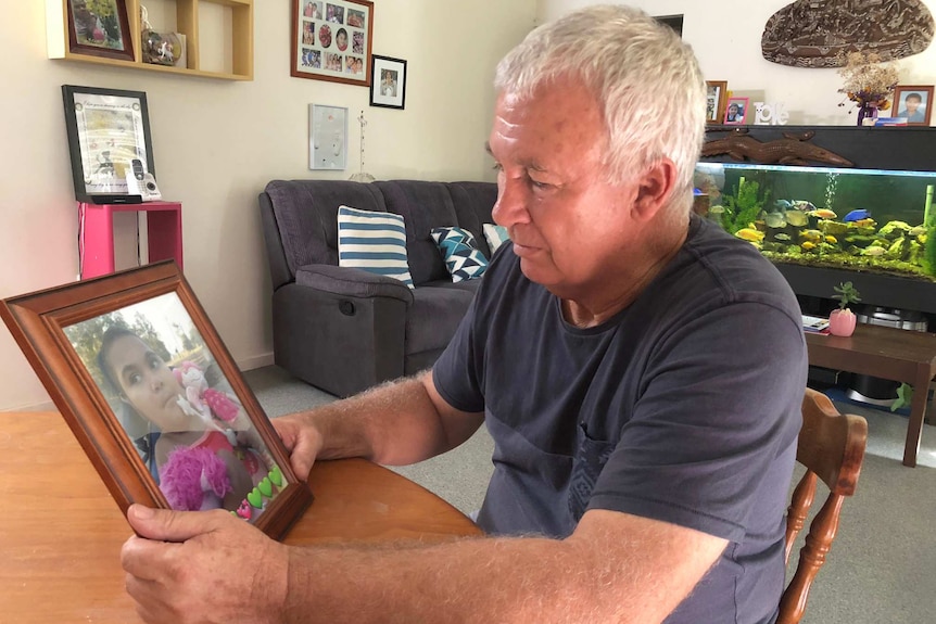 Steve Peek looks at a picture of his daughter Suli at his home.