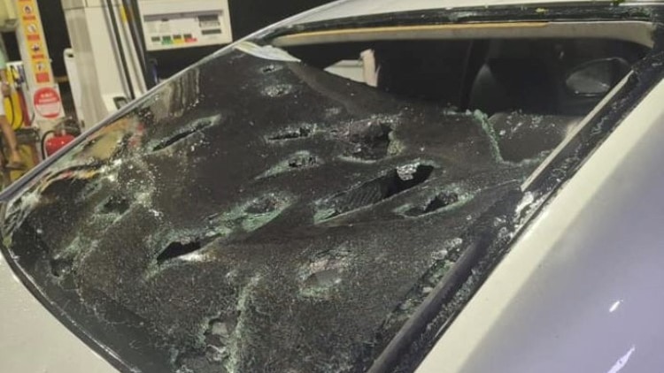 A rear car windscreen with large holes in it caused by hailstones.