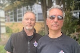 Two men standing in front of a fire station