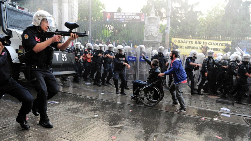 Riot police fire plastic paintball gun pellets to disperse protesters in central Istanbul.