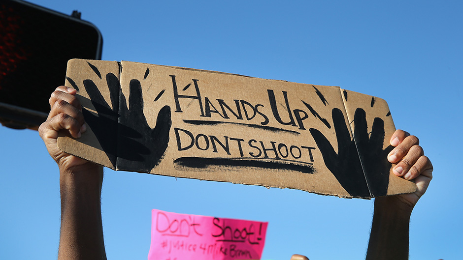 A sign at the protest over the shooting of Ferguson teenager Michael Brown reads 'Hands Up Don't Shoot'