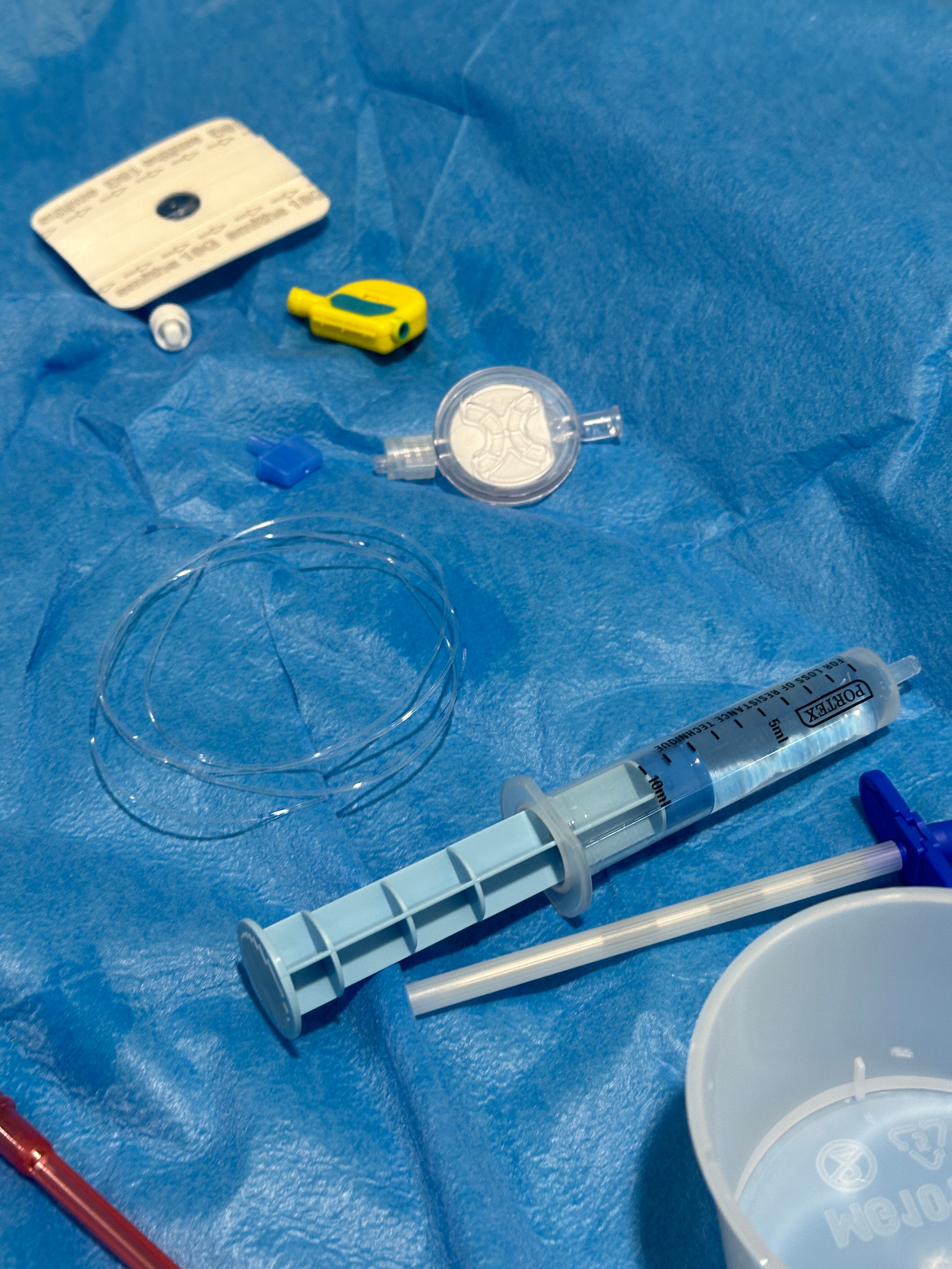 Various medical equipment is seen on a blue sheet at a hospital