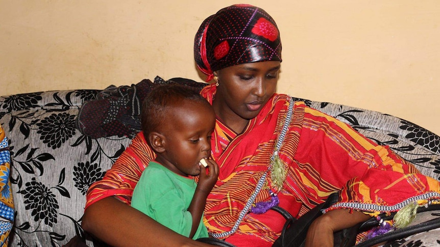 Fadumo Dayib, Somali presidential candidate sitting on a couch and holding a child.