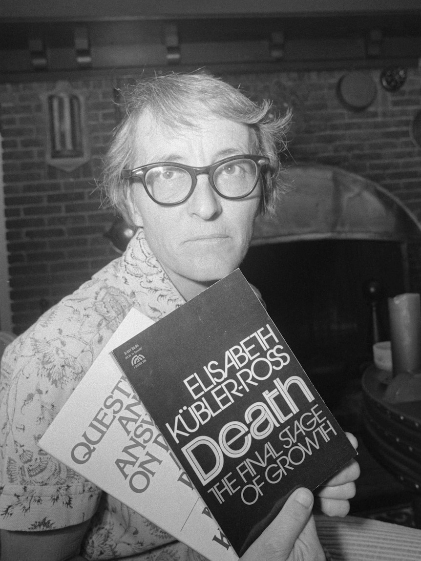 A black and white portrait of Elisabeth Kübler-Ross wearing glasses and displaying two of her books.