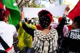 A woman in traditional Kachin clothing walks during a protest.
