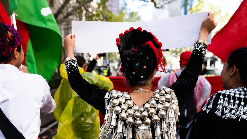 A woman in traditional Kachin clothing walks during a protest.