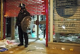 A police officer stands guard outside a looted store in Clapham Junction