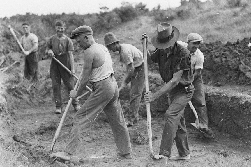 Gang of men digging black and white image.