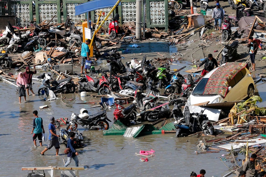 People survey the damage outside a Palu shopping mall.