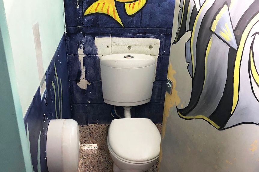 Toilet cubicle painted with bright murals on wall in a toilet block at Springwood Road State School.