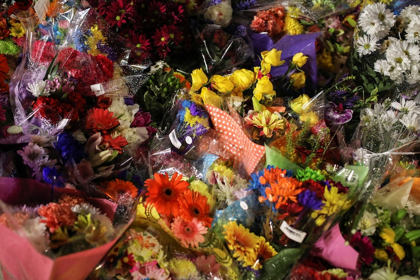 Flowers are seen at a makeshift memorial at the fatal crime.