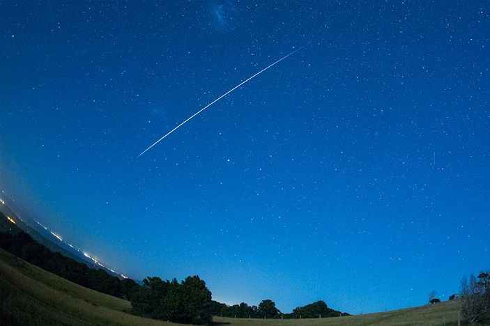 Geminid meteor streaking across the evening sky.