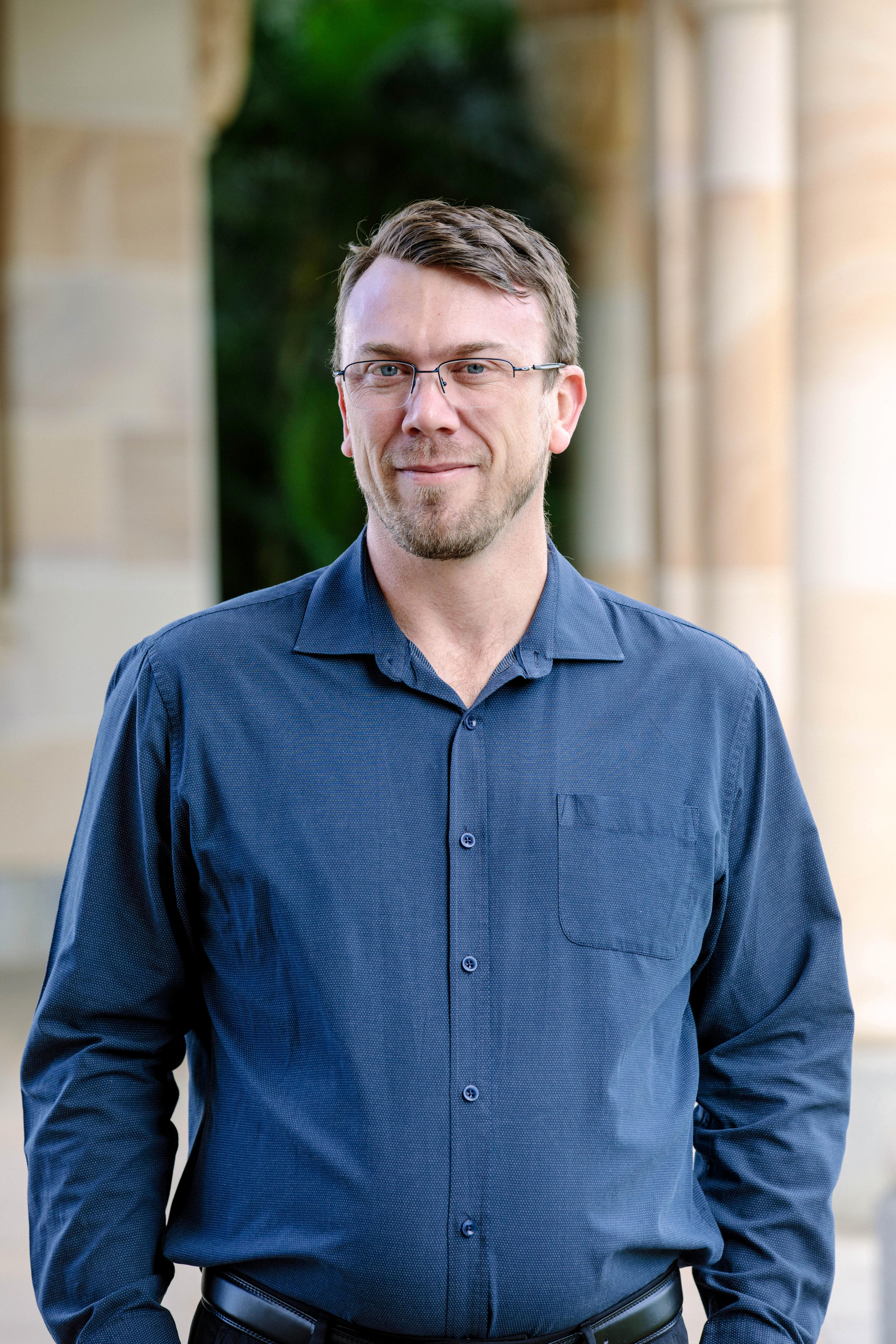 A man wearing glasses with a blue shirt