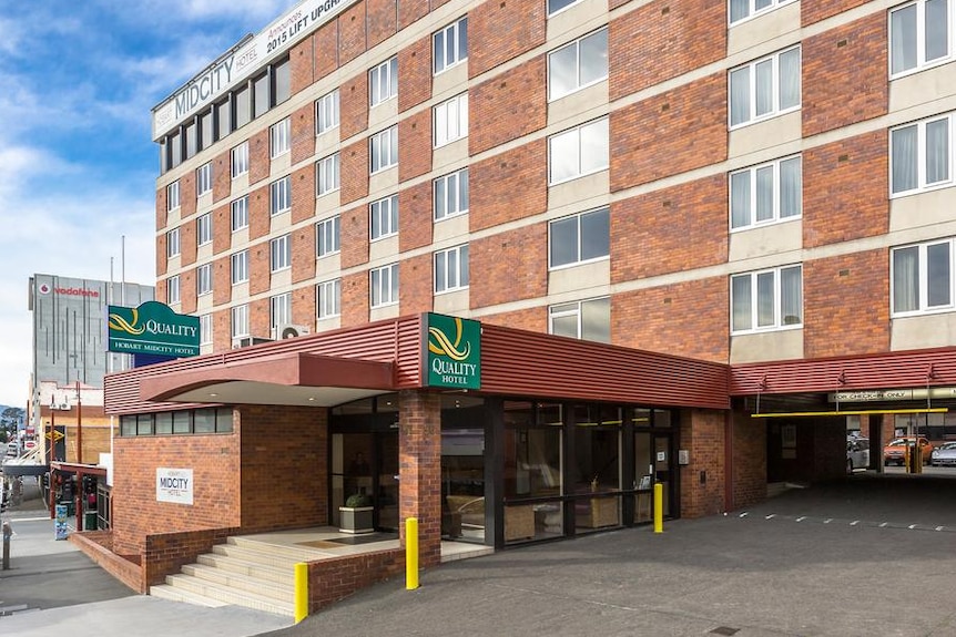 A hotel building with Quality Hotel branding is photographed from the driveway. It is a brick seven-storey building.