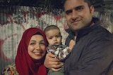 Bushra Zainuddin and her husband Zain Zafar smile as they pose for a photo with their son.