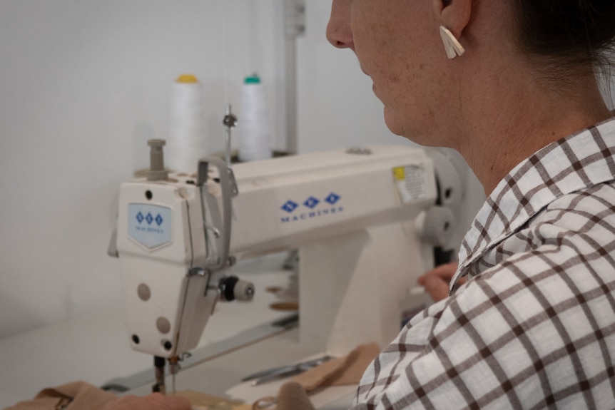 Woman sitting at industrial sewing machine