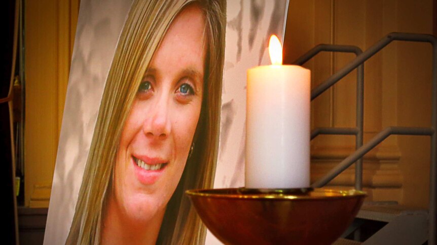 A photo of Tara Costigan next to a candle at her funeral service.