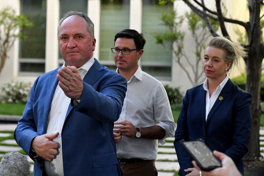 Barnaby Joyce gestures while answering questions as David Littleproud and Bridget McKenzie look on behind him