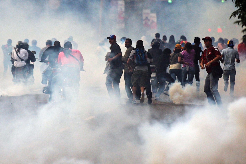 Supporters of Henrique Capriles run from tear gas.