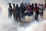 Supporters of Henrique Capriles run from tear gas.