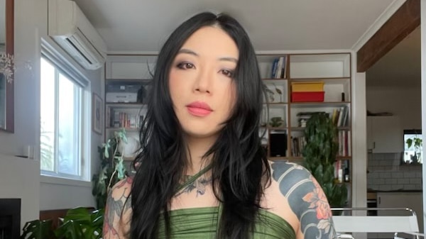 Thao Tran looking at the camera with tattoos.
