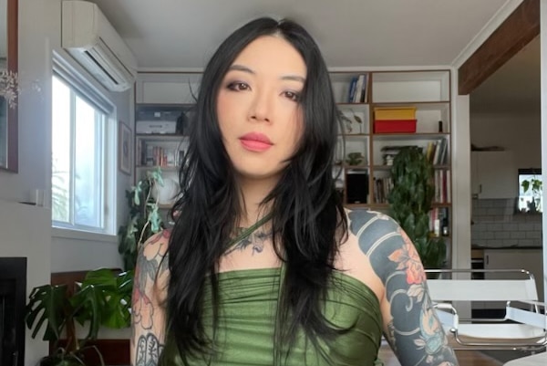 Thao Tran looking at the camera with tattoos.