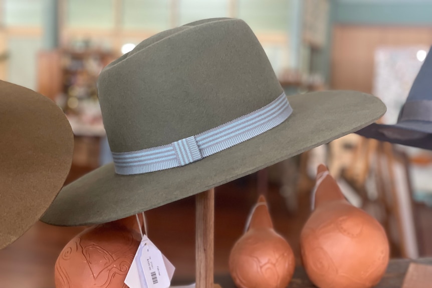 A grey felt hat with a blue bow around it 