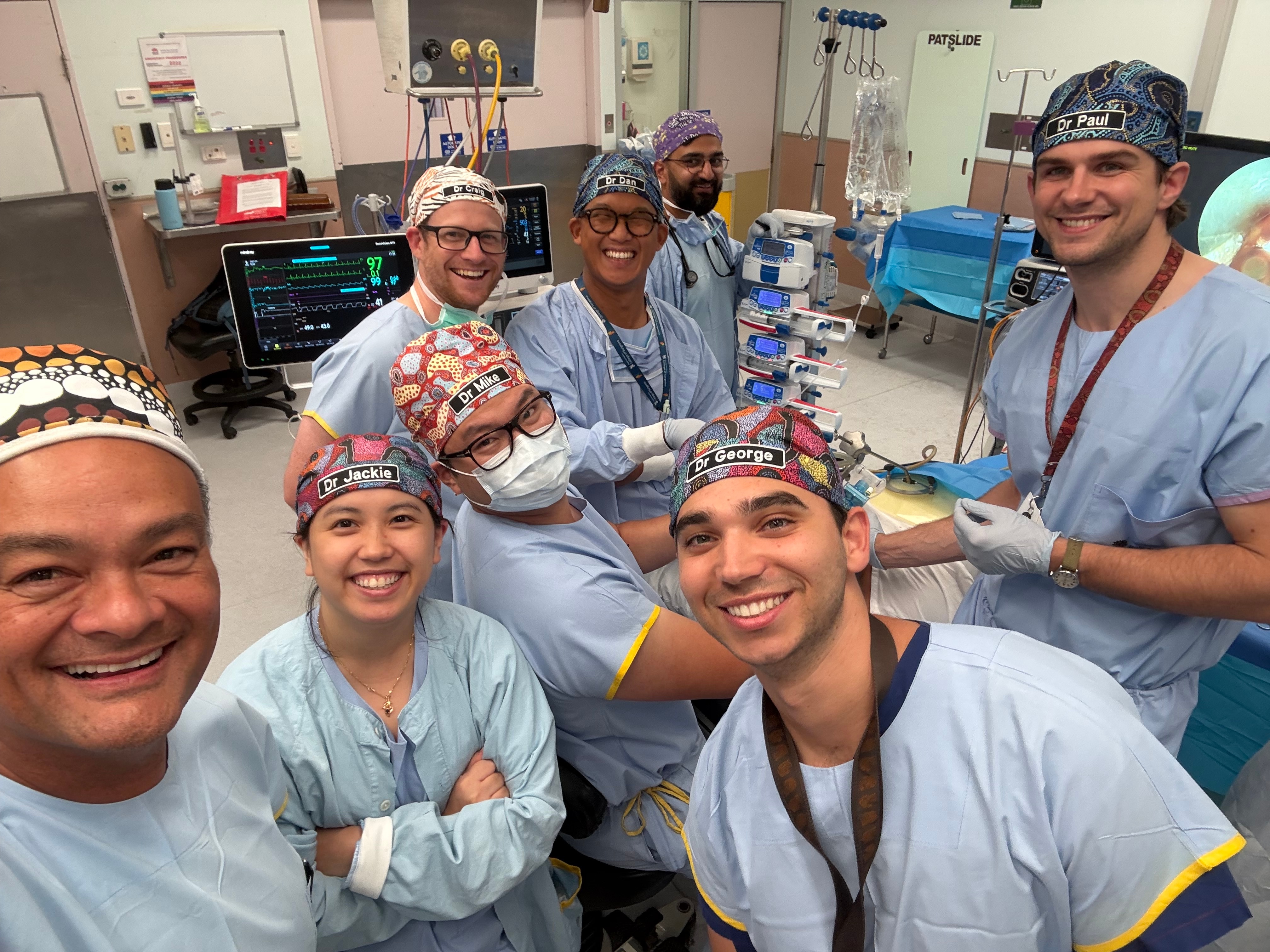 Kelvin Kong se toma una selfie con algunos colegas en bata en un hospital. 