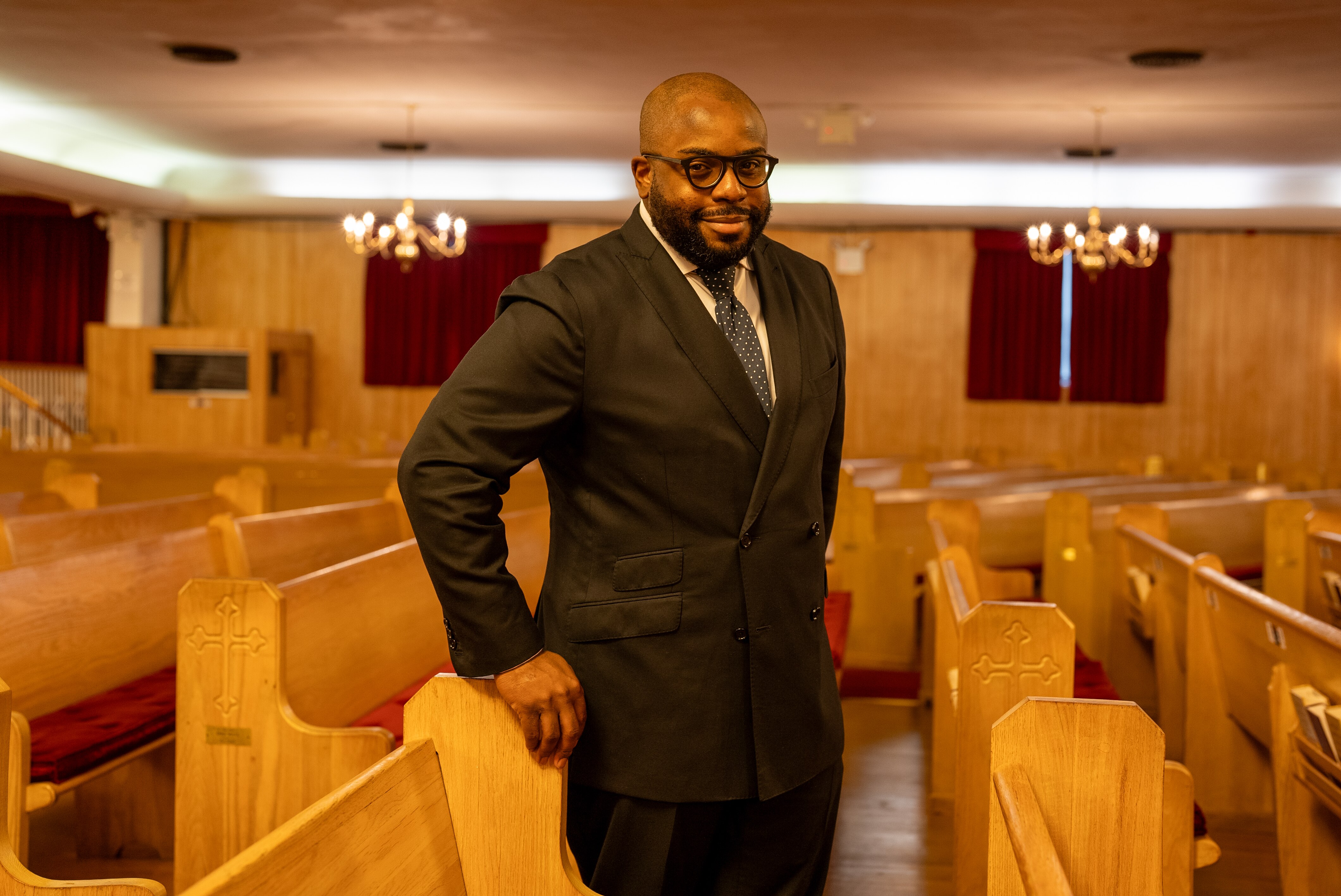 A black man in a suit standing in a church.