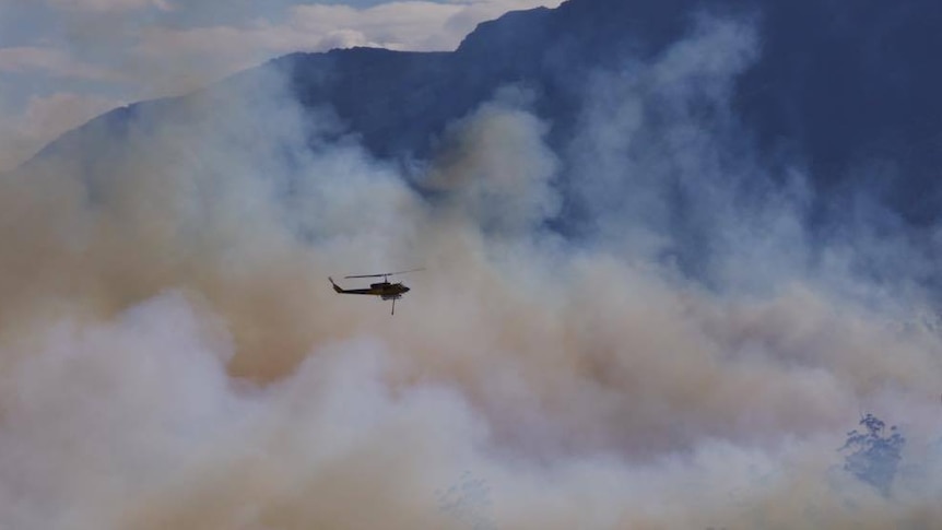 Water bombing helicopter over smoke from Lindisfarne fire