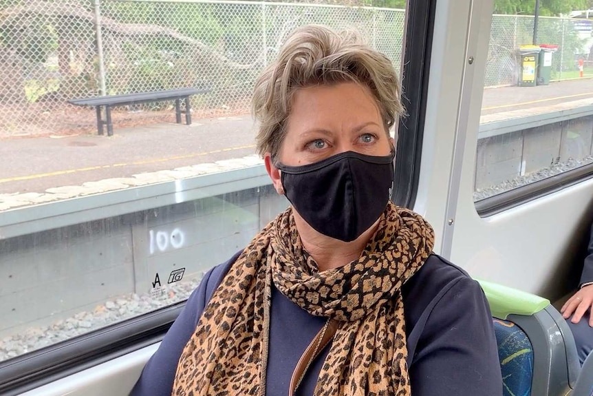 A woman wears a face mask on a Melbourne train.