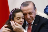 Aleppo girl Bana Alabed is hugged by Turkish President Tayyip Erdogan.