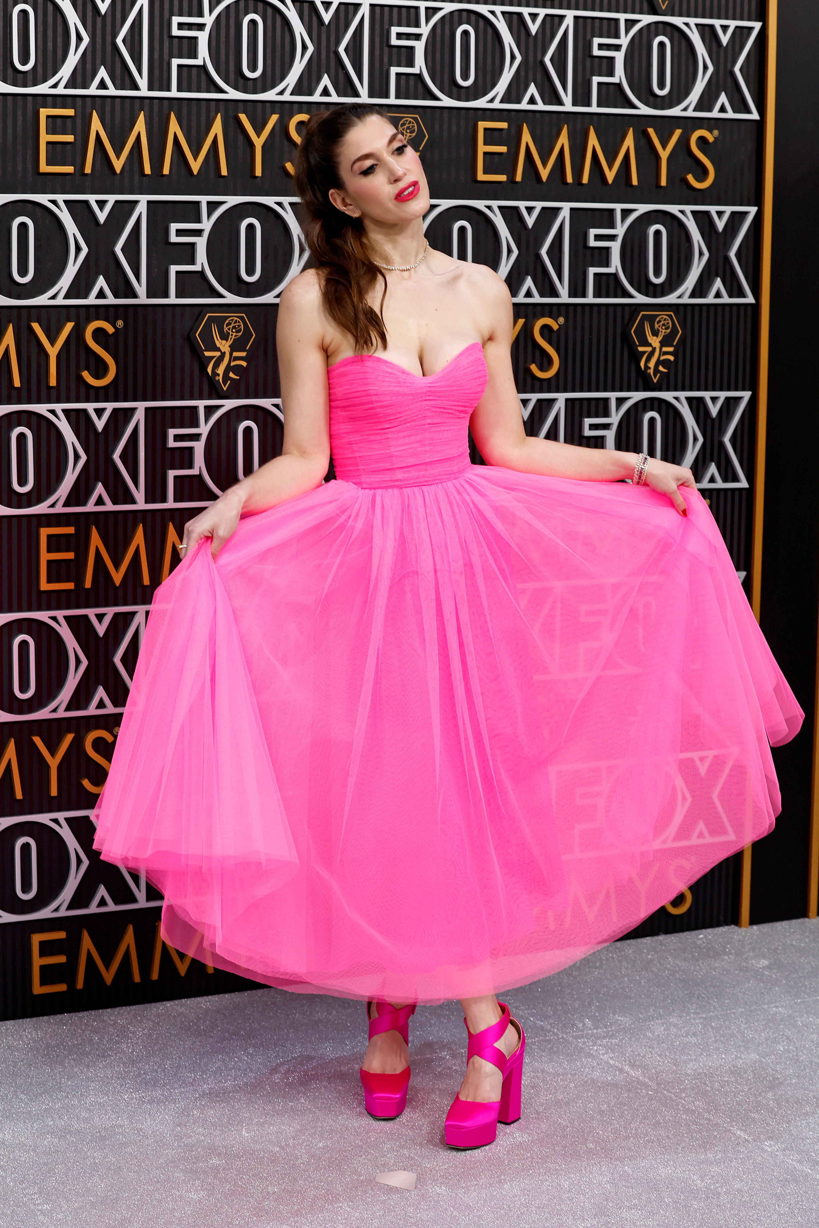 A women in a hot pink dress on a red carpet