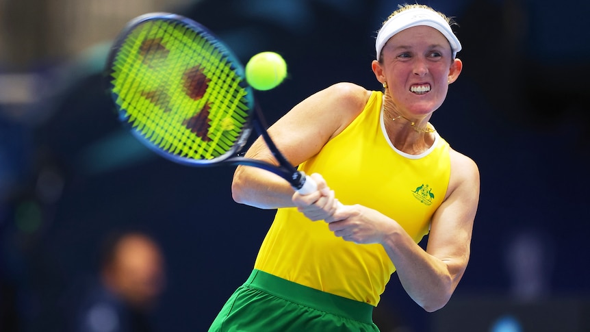 An Australian female tennis player hits a double-fisted backhand at the Billie Jean King Cup.