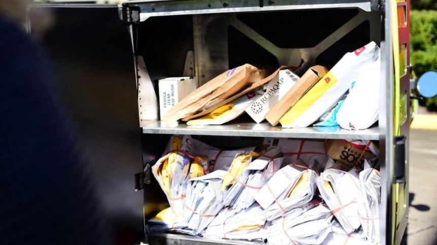 Letters and parcels sit in the back of an open post van