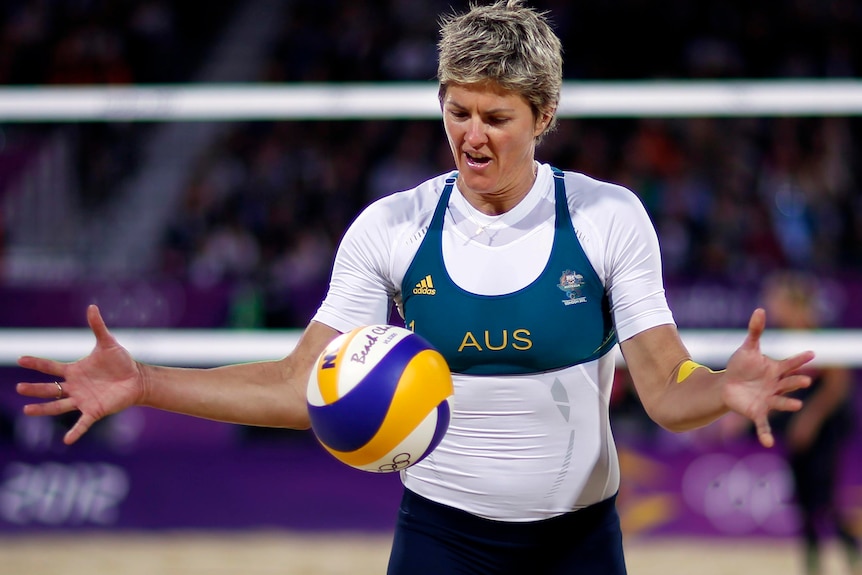 Beach volleyball player Nat Cook serves at a match at London 2012 Olympic Games.