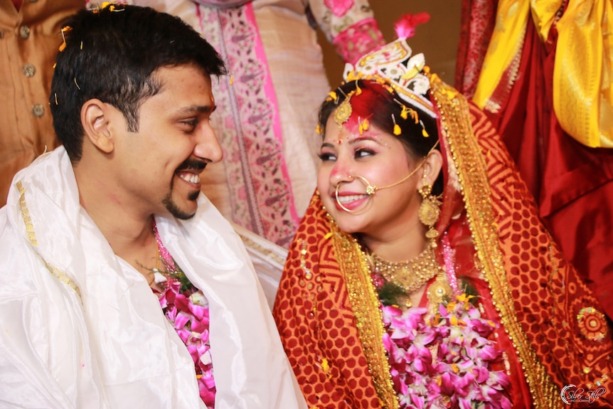 A bride and groom in traditional dress on their wedding day.