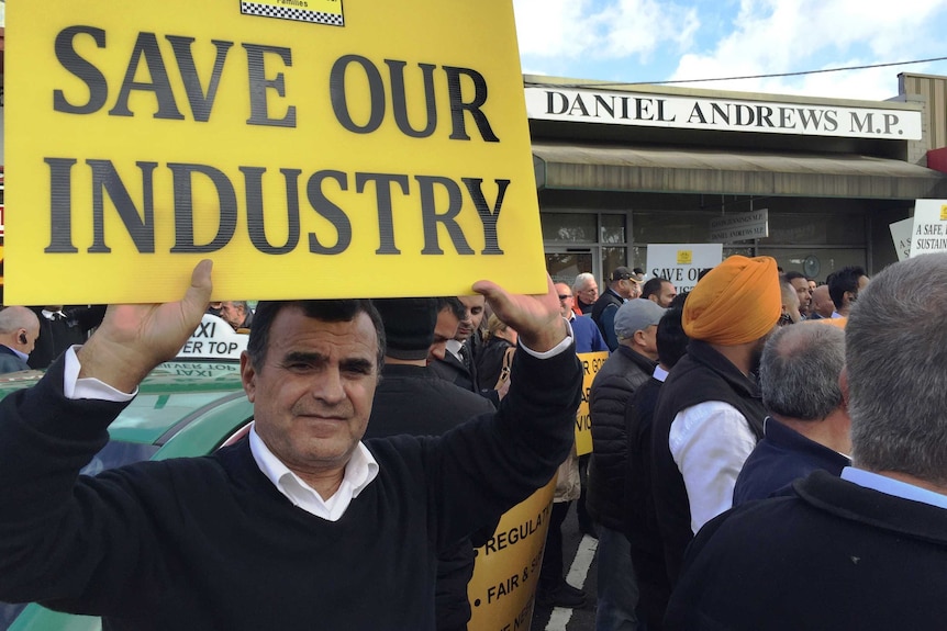 Taxi driver holding up protest sign