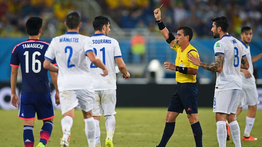 Greece's Konstantinos Katsouranis (#21) is shown his second yellow card and sent off against Japan.