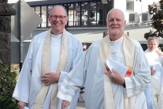 Father John Davis and Father Rob Whalley walking in their clerical vestments