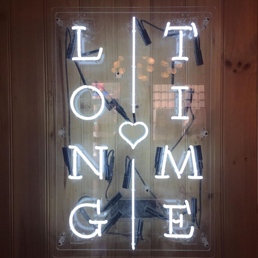 A fluoro light sign that reads "LONG TIME" vertically