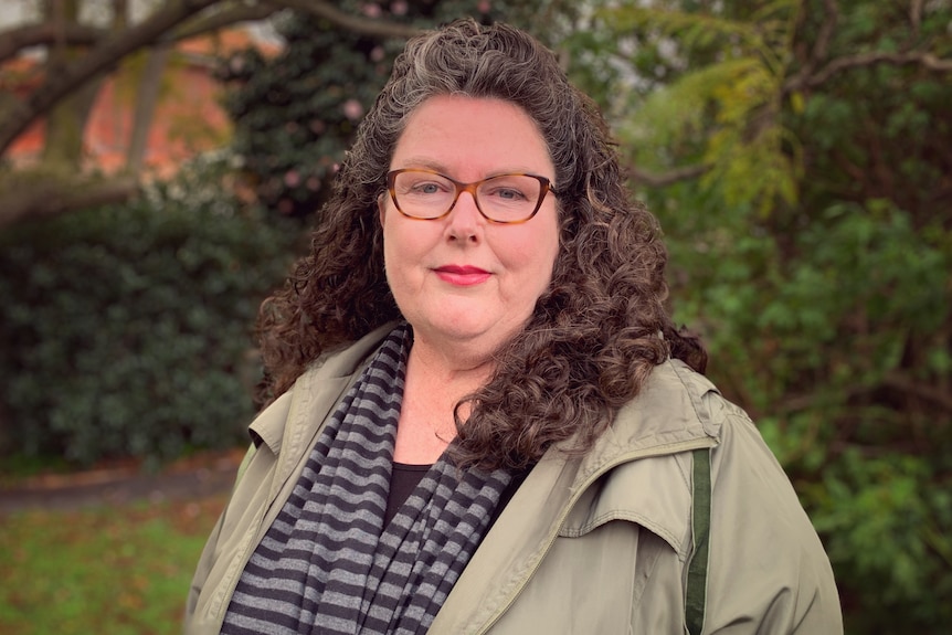 A woman in spectacles in a park.