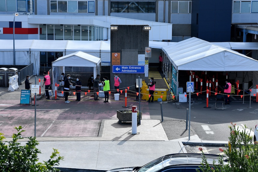 people lining up outside a vaccination hub