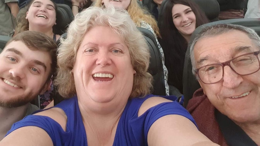 The Kirstenfeldt family smiling for a selfie on a plane.