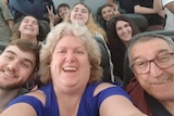 The Kirstenfeldt family smiling for a selfie on a plane.
