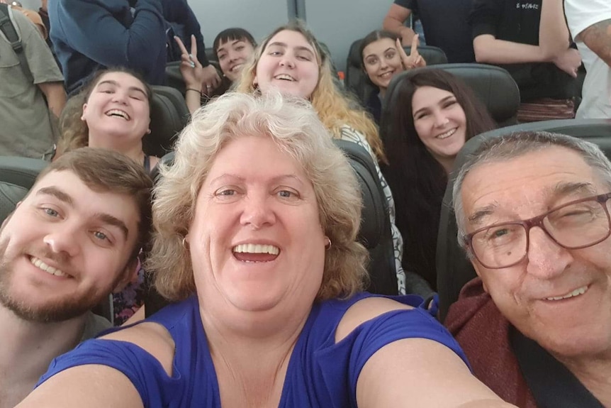 The Kirstenfeldt family smiling for a selfie on a plane.