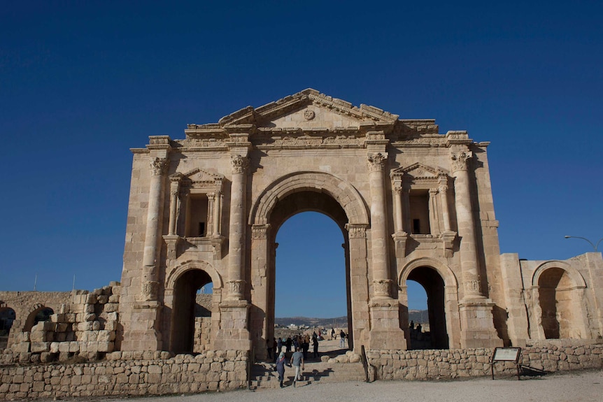 toursts walk through the arch of hardian