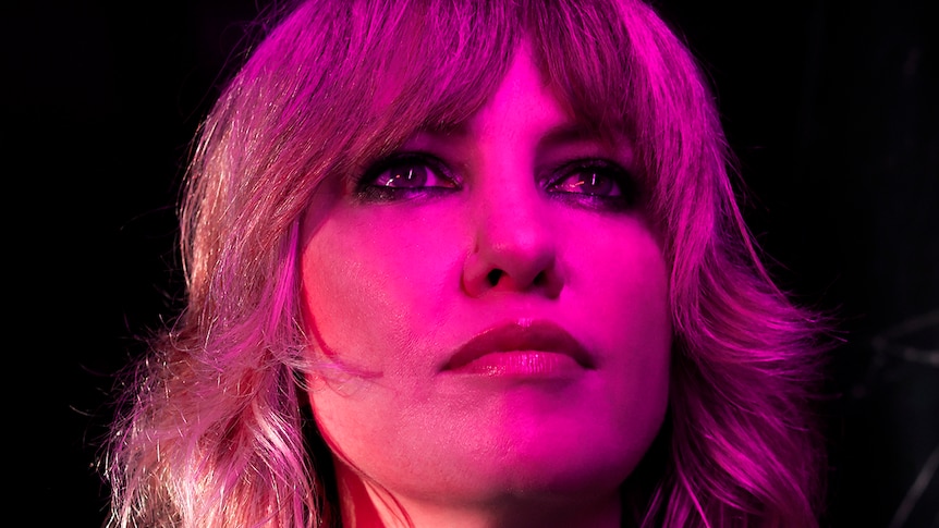 Close shot of Ladyhawke's face with a pink light on it