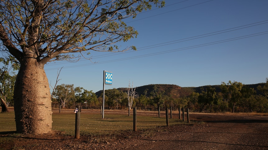 A boab tree next to a police station sign in the remote NT community of Timber Creek.