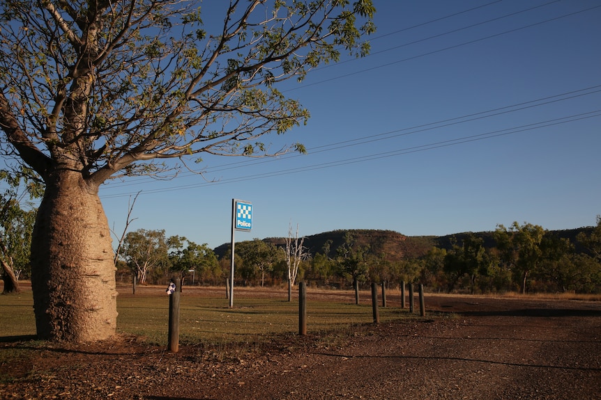 A boab tree next to a police station sign in the remote NT community of Timber Creek.